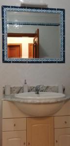 a bathroom sink with a mirror above it at Apartamento- csantos in Olhos de Água