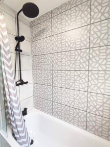 a bathroom with a shower with a tile wall at Elegant Home, Near The Beach in Blythe