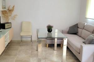- un salon avec un canapé et une table en verre dans l'établissement Casa con piscina privada y jardín, à Chiclana de la Frontera