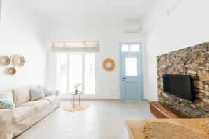 a living room with a couch and a tv at Helona guesthouse, Skopelos in Skopelos Town
