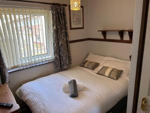 - un petit lit avec 2 oreillers dans une chambre dans l'établissement Central Aster House, 3 Bedrooms, Parking, à Nottingham