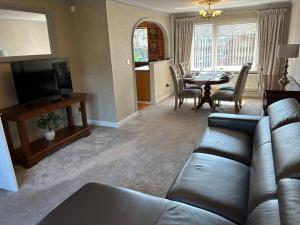 a living room with a couch and a dining room at Central Aster House, 3 Bedrooms, Parking in Nottingham