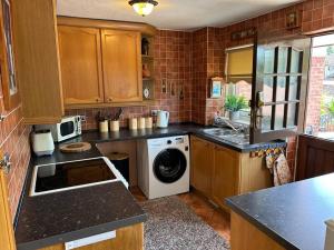 a kitchen with a washer and dryer in it at Central Aster House, 3 Bedrooms, Parking in Nottingham