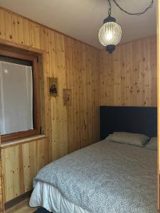 a bedroom with wooden walls and a bed and a window at Casa DANIEL in Castel di Sangro