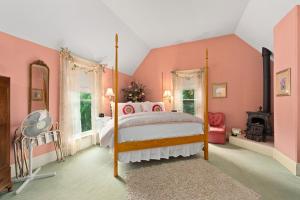 a pink bedroom with a bed and a fireplace at The Gables Wine Country Inn in Santa Rosa