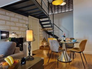 a living room with a couch and a table with chairs at Duplex Chic Climatisé avec terrasse proche Comédie in Montpellier