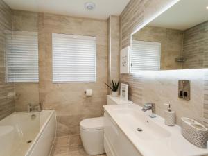 a bathroom with a sink and a toilet and a tub at Polished Pebble in Beadnell +40 photos