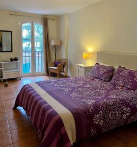 サンタ・ウルスラにあるLagos de La Quintaのベッドルーム(紫色のベッド1台、窓付)