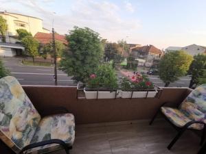 two chairs on a balcony with a view of a street at Old Town Apartment 2 bedrooms, 1 living in Baia Mare +3 photos