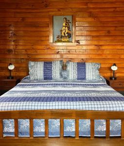 uma cama num quarto com paredes de madeira em Cabañas Doña Mónica em Recinto