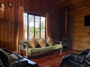 a living room with a couch and a large window at Cabañas Doña Mónica in Recinto