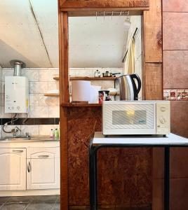eine Küche mit einem Tisch und einer Mikrowelle in der Unterkunft Cabañas Doña Mónica in Recinto