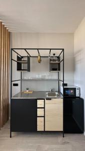 eine Küche mit einer Theke mit einer Spüle und einer Mikrowelle in der Unterkunft Angel Apt-Amazing SeaView-Netfix-Wifi-Free Parking in Aschdod