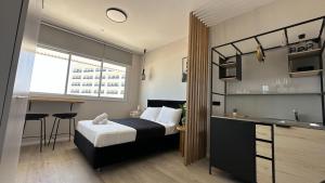 a bedroom with a bed and a desk and a kitchen at Angel Apt-Amazing SeaView-Netfix-Wifi-Free Parking in Ashdod