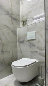 um WC branco numa casa de banho com paredes em mármore em Angel Apt-Amazing SeaView-Netfix-Wifi-Free Parking em Ashdod
