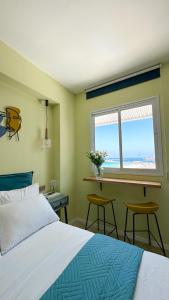 a bedroom with a bed and a desk and a window at Angel Apt-Amazing SeaView-Netfix-Wifi-Free Parking in Ashdod