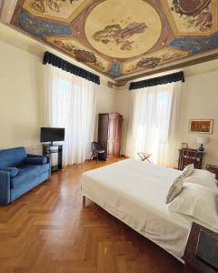 ein Schlafzimmer mit einer Decke, einem Bett und einem Sofa in der Unterkunft Cimabue 9 in Florenz