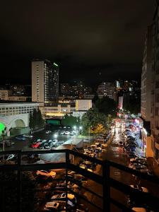 eine belebte Stadtstraße nachts mit parkenden Autos in der Unterkunft Lost in Tbilisi in Tbilisi City