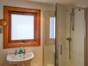 a bathroom with a sink and a shower with a window at Larch Lodge - Uk37187 in Legbourne
