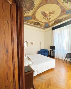 1 dormitorio con 1 cama y una pintura en el techo en Cimabue 9, en Florencia