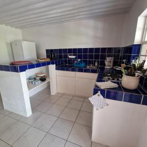 a kitchen with blue tiles on the walls and counters at Nos Soño Stay and Dive in Westpunt