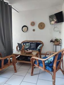 a living room with a couch and a table and chairs at APPARTEMENT 2 CHAMBRES A POINTE A PITRE in Pointe-à-Pitre