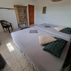 uma grande cama branca num quarto com uma cadeira em Nos Soño Stay and Dive em Westpunt