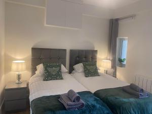 um quarto com 2 camas e toalhas em The Cwtch Pet Friendly Ground Floor Flat Near M4 and Porthcawl em Kenfig Hill