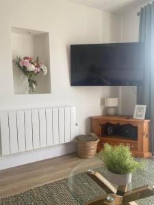 a living room with a flat screen tv on a wall at The Cwtch Pet Friendly Ground Floor Flat Near M4 and Porthcawl in Kenfig Hill