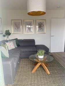 uma sala de estar com um sofá azul e uma mesa em The Cwtch Pet Friendly Ground Floor Flat Near M4 and Porthcawl em Kenfig Hill