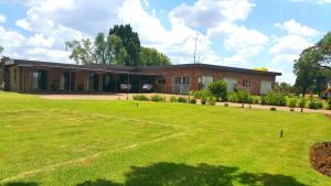 a brick house with a large lawn in front of it at Korundum Lodge in Vereeniging