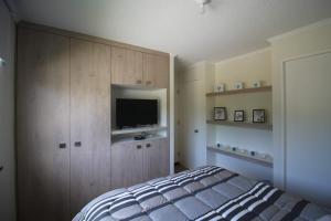 um quarto com uma cama e uma televisão de ecrã plano em Casa Pucón em Pucón