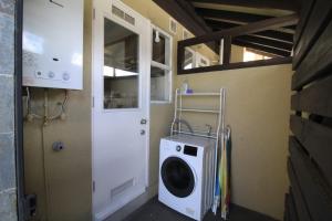 lavadero con lavadora y puerta en Casa Pucón en Pucón