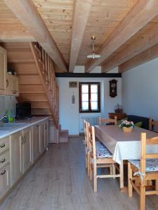 eine Küche und ein Esszimmer mit einem Tisch und Holzdecken in der Unterkunft Casa Elisa apartment in Armeno