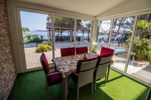 a dining room with a table and chairs and a window at Villa Petrac - App1 in Rab