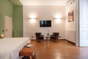 Habitación de hotel con cama y TV en la pared en De deo 98-modern hospitality-, en Nápoles