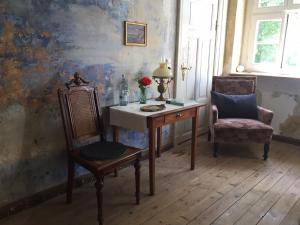 a room with a desk and two chairs and a table at Gut Manderow an der Ostsee in Hohenkirchen