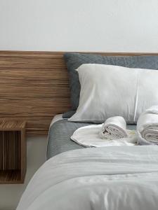 1 cama con sábanas y almohadas blancas y cabecero de madera en Praia Comprida Hotel, en São José