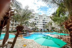 an image of a resort swimming pool with umbrellas at Thermas Paradise Rio Quente Flats 332 in Rio Quente