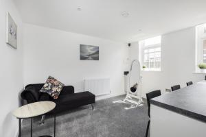 a living room with a black couch and a table at Modern 2bed Apartment in Worksop in Worksop