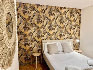 a bedroom with a bed with a yellow and blue wallpaper at Grand appartement Bron centre proche Eurexpo et Groupama in Bron