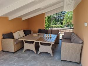 un patio con mesa de madera y sillas en Lilian apartmanház, en Siófok