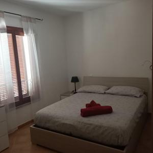 a red pillow on a bed in a bedroom at Santa Teresa Gallura Green House in Santa Teresa Gallura