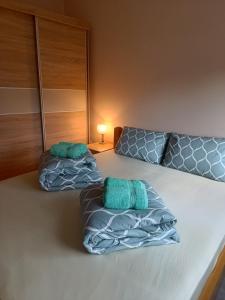 Una cama con dos almohadas verdes encima. en Zvezdica en Banja Koviljača