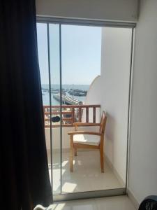 a chair on a balcony with a view of the ocean at Hotel Riviera Inka Paracas in Paracas