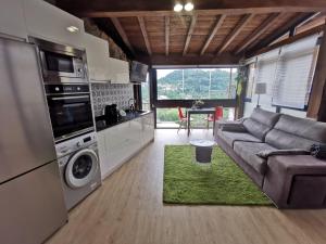 a living room with a couch and a kitchen at O Recuncho de Tibias in Pereiro de Aguiar