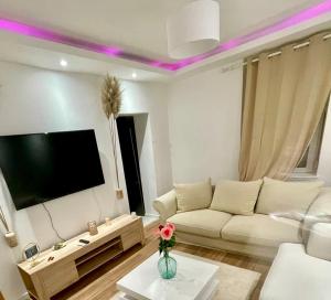 a living room with a white couch and a flat screen tv at Coockooning Led in Basse-Yutz