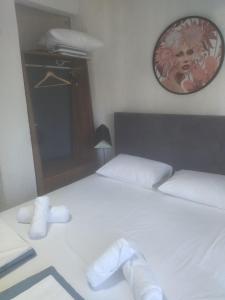 1 dormitorio con 1 cama con sábanas blancas y espejo en PELEKAN rooms and apartments ATHINA 23, en Pefkohori