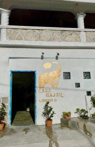 una señal en el lateral de un edificio con una puerta en Casa Gajah Hotel Cuyo en El Cuyo