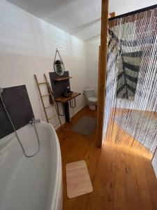 a bathroom with a bath tub and a wooden floor at Maison typique Maillé 